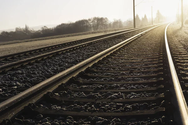 Железнодорожные пути на рассвете. Железнодорожная инфраструктура и солнечный луч — стоковое фото