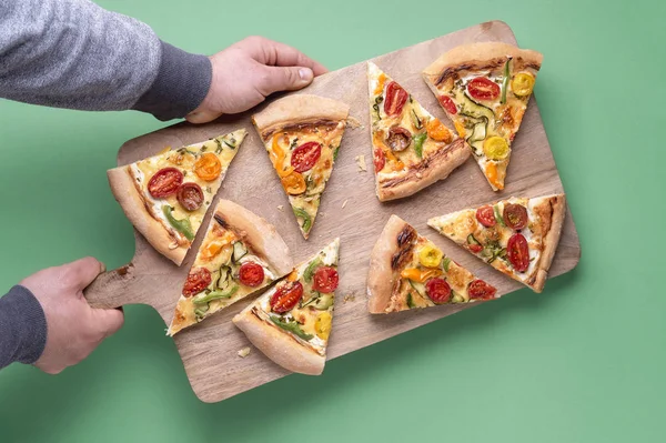 Pizza slices on wooden cutting board. Pizza primavera
