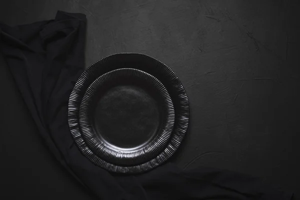 Vajilla y toalla vacías. Platos negros en la mesa. Platos vacíos — Foto de Stock