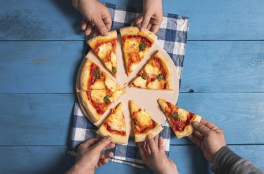 Pizza dilimleri alıyorum. İnsanlar pizza margherita dilimleri alıyor.