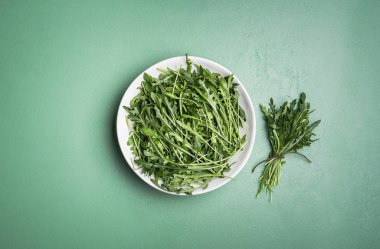 Arugula salatası ve roka tomarı yeşil masada. Taze bitkiler. 