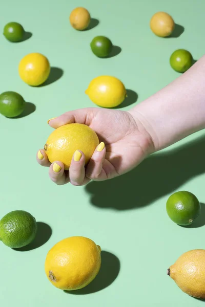 Citrus fruits and hand holding a lemon. Summer fresh fruits — ストック写真