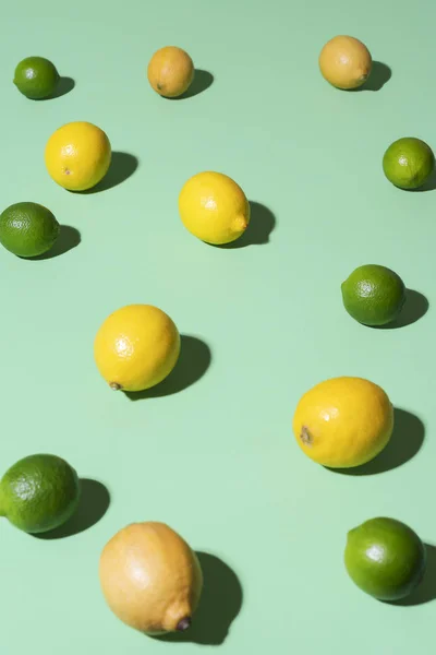 Lemons and limes fruits on a green background. Summer fruits — ストック写真