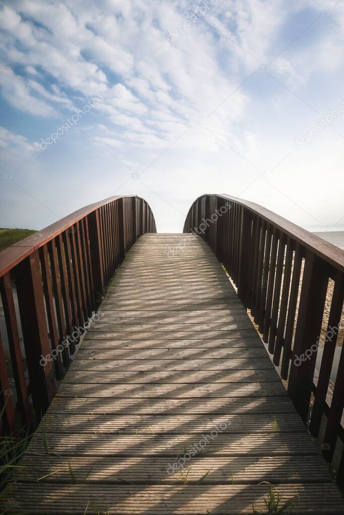 Bridge going up toward sky. Walkway on Sylt island, at North sea