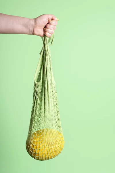Yellow melon hanging in reusable mesh shopping bag. Buying fruit — 스톡 사진