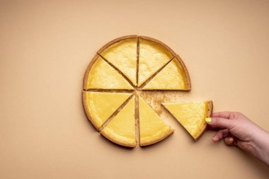 Krem renkli arka planda cheesecake. Kadın eli.