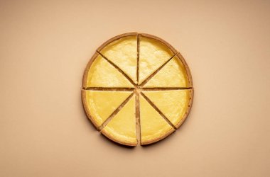 Sarı arka planda dilimlenmiş cheesecake. Eşit dilimlenmiş pasta.