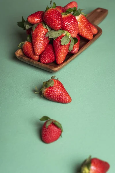 Teller mit Erdbeeren auf grünem Tisch. Frische reife Erdbeerfrucht — Stockfoto