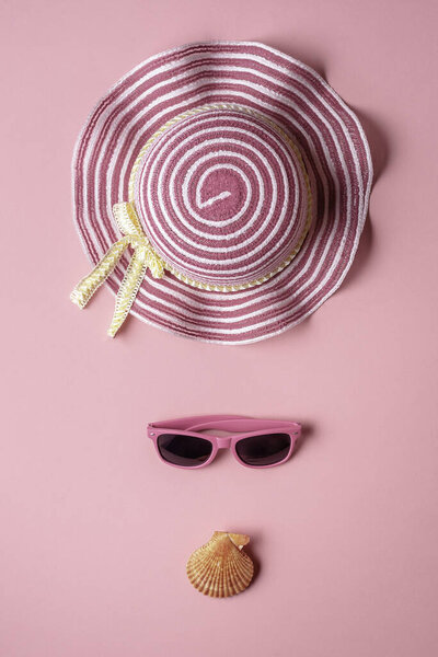 Summer banner with pink hat and sunglasses, on pink seamless background. Colorful beach accessories and seashells.