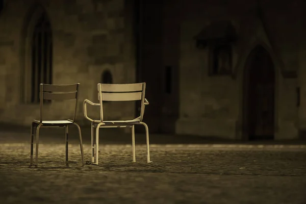 Open-air theater chairs in Zurich square, at night. Two empty seats on Zurich streets, Switzerland. Retro metal chairs in night scenery.