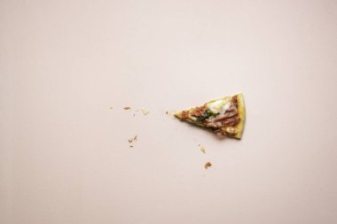 Pembe arka planda peynirli ve roka aromalı tek dilim pizza. Jambonlu pizzanın son parçası. İtalya 'nın popüler yemekleri.