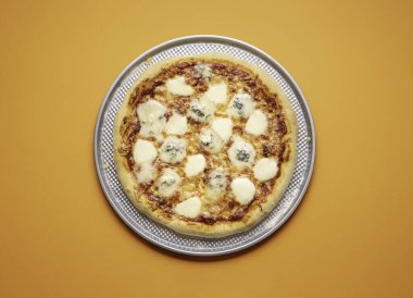 Quattro formaggi pizza, portakalsız arka planda metal bir fırın tepsisinde. Gorgonzola ve mozzarella peynirli dört peynirli pizza. İtalyan yemeği..