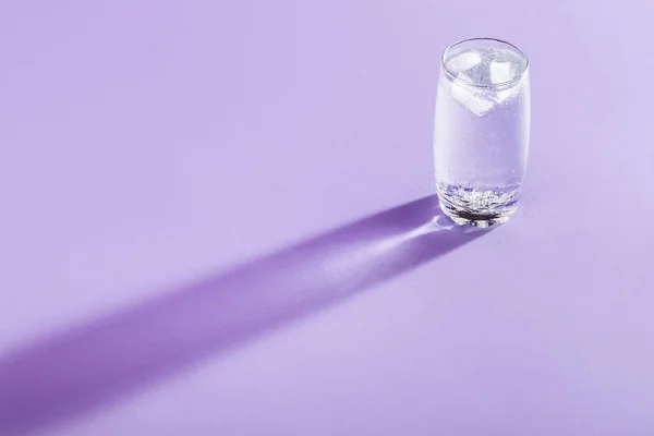 Enkelglas Med Tonic Vatten Och Isbitar Lila Bakgrund Kallvatten Ett — Stockfoto