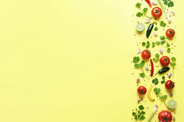 The original salsa sauce ingredients on a yellow background above view. Fresh vegetables, herbs and condiments used to make the mexican salsa sauce.