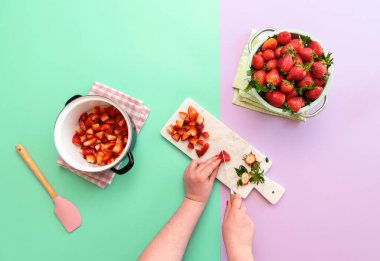 Çilek reçeli hazırlayan kadın duotonsuz arka planda. Marmelat yapımıyla yatıyordu. Reçel yapmak için çilek dilimliyorum..