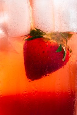 Çilekli limonata yakın plan. Soğuk yaz içeceği makro detayları çilek, buz küpleri ve kırmızı şurupla birlikte. Tatlı içecek tazeleniyor.