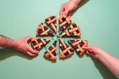 Elleri turta dilimleyen gençlerle dolu. Ev yapımı nefis yaban mersinli kek ve kafes kabuğu.