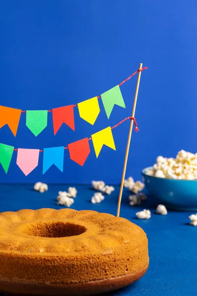 Kukuřičný Koláč Pestrobarevnými Vlajkami Brazilské Sladké Jídlo Popcorn Modrém Stole — Stock fotografie