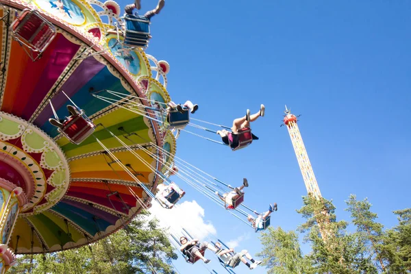 Parco divertimenti Tykkimaki, Kouvola, Finlandia 13.07.2017. Giostra variopinta dell'oscillazione della catena in movimento al parco di divertimenti sullo sfondo blu del cielo . — Foto Stock