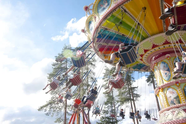 Amusement park Tykkimaki, Kouvola, Finland 13.07.2017. Colorful chain swing carousel in motion at amusement park on blue sky background. — Stock Photo, Image