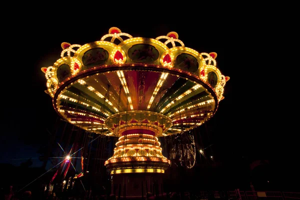 Carrousel balançoire coloré en mouvement au parc d'attractions la nuit . — Photo