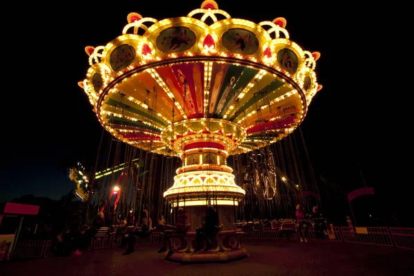 Colorful chain swing carousel in motion at amusement park at night. — Stock Photo, Image