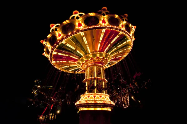 Carrousel balançoire coloré en mouvement au parc d'attractions la nuit . — Photo