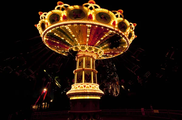 Kleurrijke keten swing carrousel in beweging op pretpark bij nacht. — Stockfoto