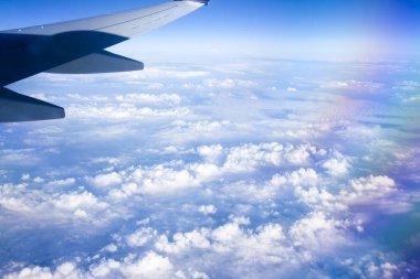 Mavi gökyüzü ve beyaz bulutlu uçak penceresinden bak.