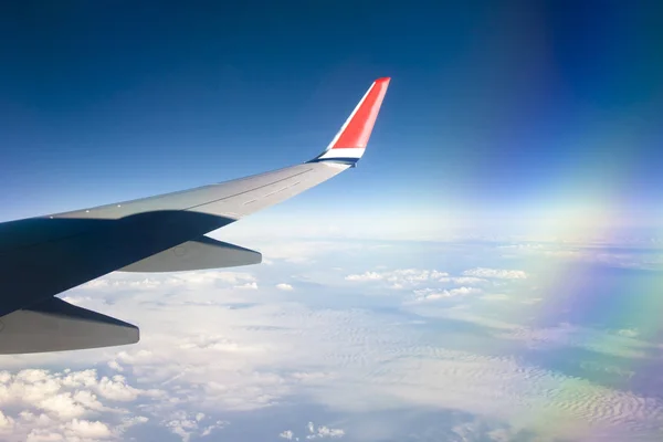 Θέα από το παράθυρο του αεροπλάνου με μπλε ουρανό και άσπρα σύννεφα. — Φωτογραφία Αρχείου