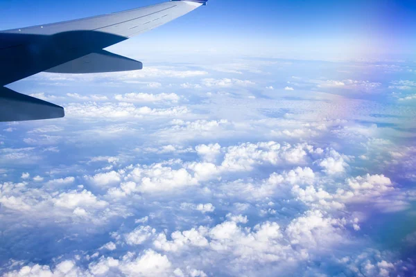 Mavi gökyüzü ve beyaz bulutlu uçak penceresinden bak.