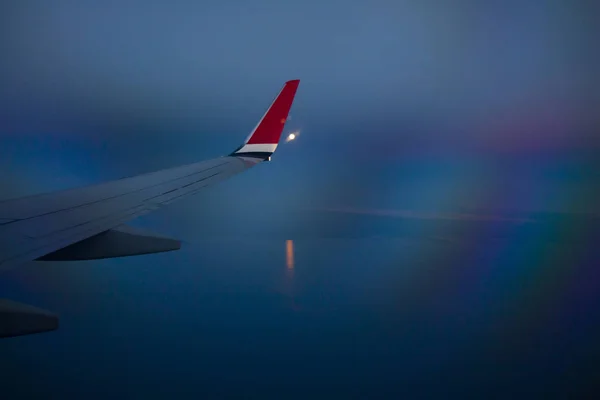 Vista desde la ventana del avión con cielo nocturno y nubes blancas . —  Fotos de Stock