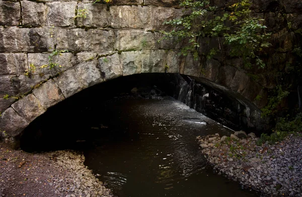 Old stone bridge coverd with moss and torrential river. — Stock Photo, Image