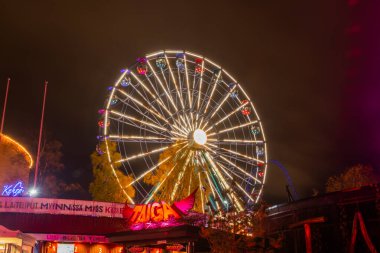 Helsinki, Finlandiya - 19 Ekim 2019: Linnanmaki lunaparkında düzenlenen Işık Karnavalı. Gece aydınlığında dönme dolaba bin..