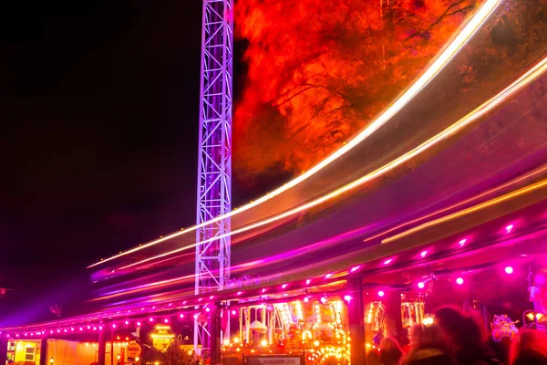 Helsinki, Finlande - 19 octobre 2019 : Le Carnaval de la Lumière au parc d'attractions Linnanmaki. Monter le train Maisemajuna en mouvement. Éclairage nocturne, longue exposition . — Photo