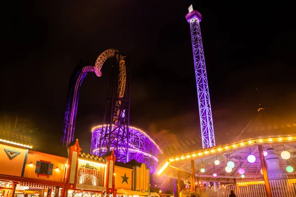 Helsinki, Finlandia - 19 października 2019: Karnawał Światła w parku rozrywki Linnanmaki. Jazda na Raketti, Ukko i roller coaster Vuoristorata w oświetleniu nocnym. — Zdjęcie stockowe