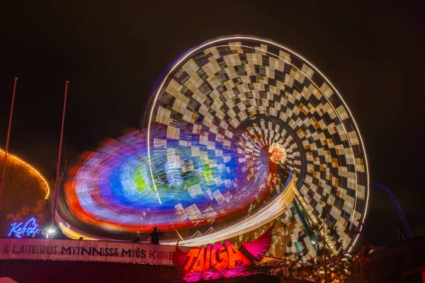 Helsinki, Finlande - 19 octobre 2019 : Le Carnaval de la Lumière au parc d'attractions Linnanmaki. Ride Ferris Wheel Rinkeli et Kehra en mouvement, éclairage nocturne, longue exposition . — Photo