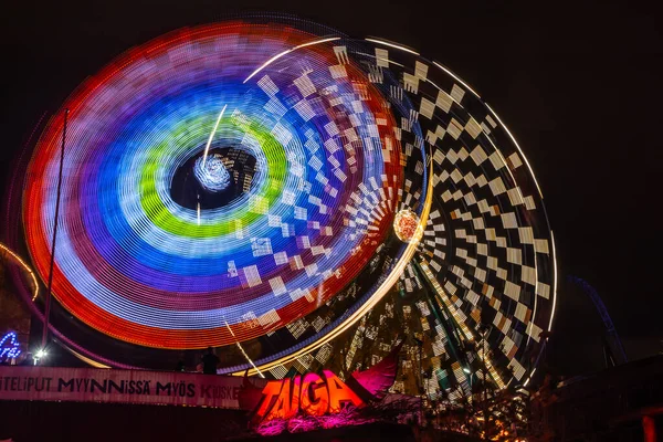 Helsinki, Finlandia - 19 de octubre de 2019: El evento Carnaval de la Luz en el parque de atracciones Linnanmaki. Ride Ferris Rueda Rinkeli y Kehra en movimiento, iluminación nocturna, larga exposición . —  Fotos de Stock