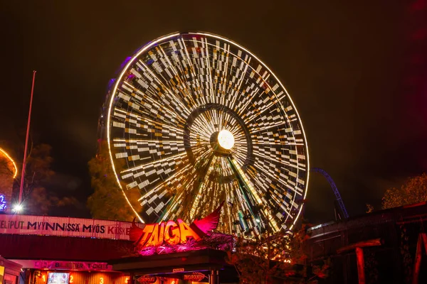 Helsinki, Finlande - 19 octobre 2019 : Le Carnaval de la Lumière au parc d'attractions Linnanmaki. Ride Ferris Wheel Rinkeli en mouvement, éclairage nocturne, longue exposition . — Photo
