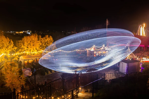 Helsinki, Finland - 19 October 2019: The Carnival of Light event at the Linnanmaki amusement park. Ride Magia in motion, night illumination. Long exposure. — ストック写真