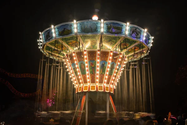 Helsinki, Finland - 19 October 2019: The Carnival of Light event at the Linnanmaki amusement park. Ride chain carousel Ketjukaruselli in night illumination. — ストック写真