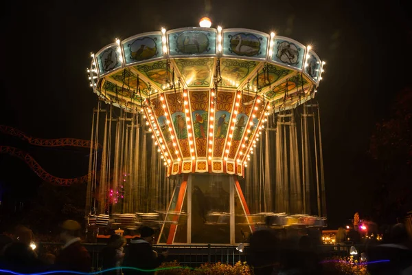 Helsinki, Finland - 19 October 2019: The Carnival of Light event at the Linnanmaki amusement park. Ride chain carousel Ketjukaruselli in night illumination. — ストック写真