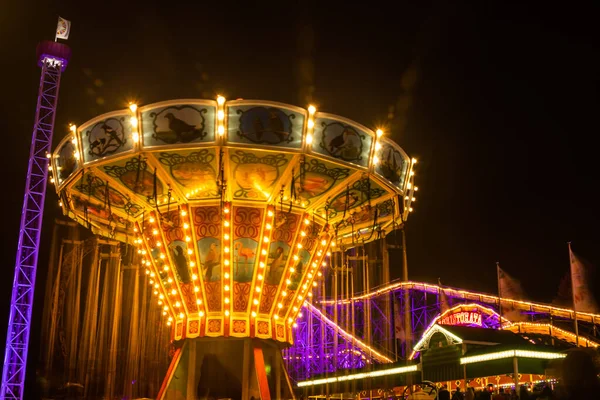 Helsinki, Finland - 19 October 2019: The Carnival of Light event at the Linnanmaki amusement park. Ride chain carousel Ketjukaruselli in night illumination. — ストック写真