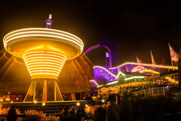 Helsinki, Finland - 19 October 2019: The Carnival of Light event at the Linnanmaki amusement park. Ride chain carousel Ketjukaruselli in motion. Night illumination, long exposure. — ストック写真