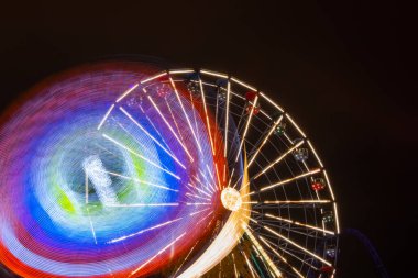 Lunaparkta iki gezinti, gece aydınlatması. Uzun pozlama.