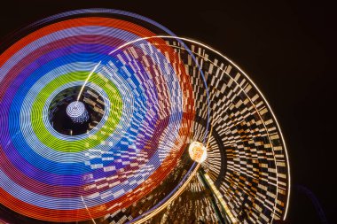 Lunaparkta iki gezinti, gece aydınlatması. Uzun pozlama.