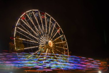 Lunaparkta iki gezinti, gece aydınlatması. Uzun pozlama.