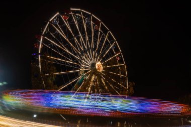Lunaparkta iki gezinti, gece aydınlatması. Uzun pozlama.