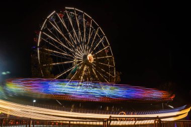 Lunaparkta iki gezinti, gece aydınlatması. Uzun pozlama.