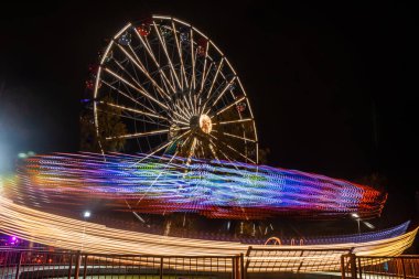 Lunaparkta iki gezinti, gece aydınlatması. Uzun pozlama.